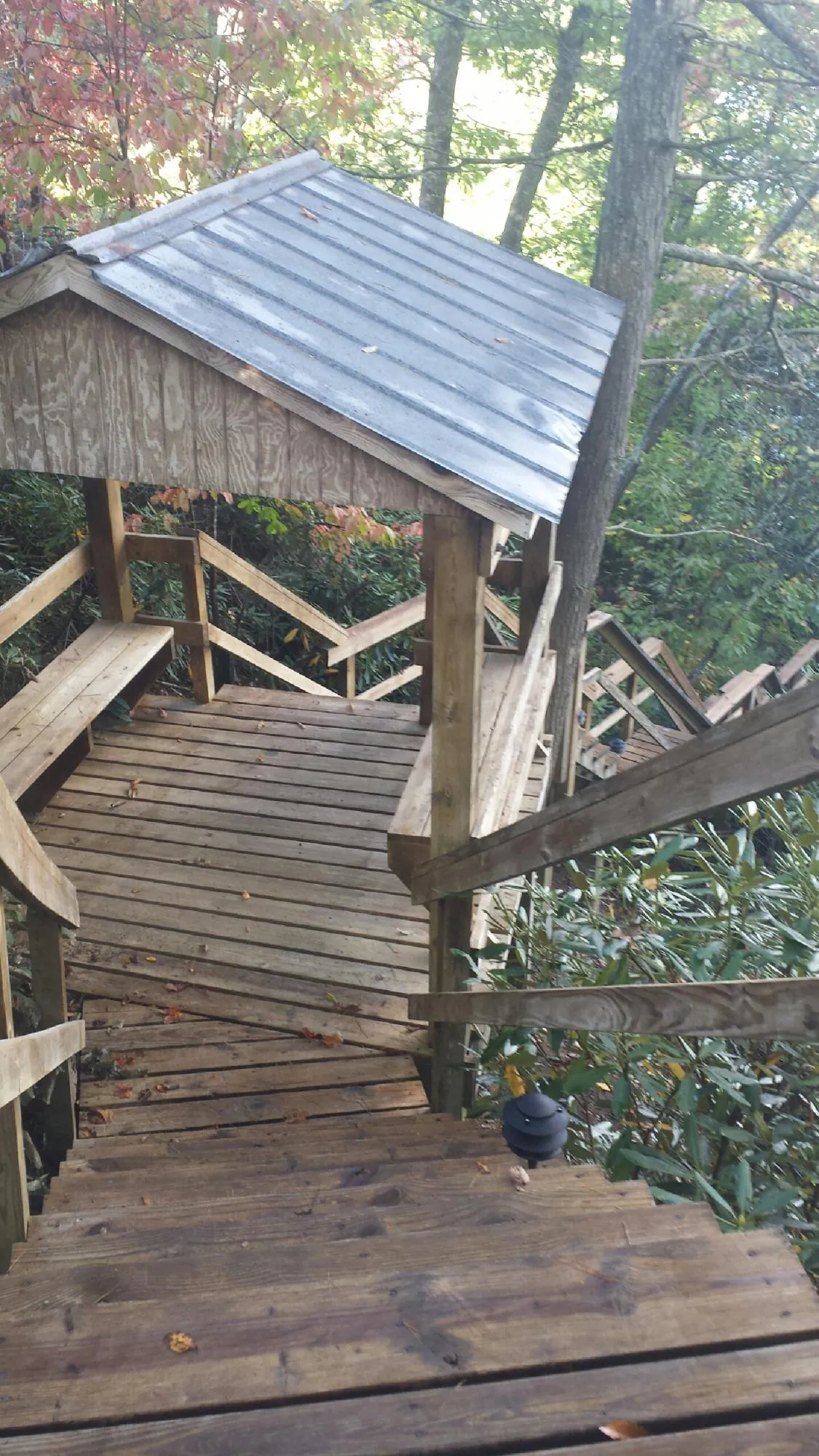 Metal roofed shelter over wooden steps on a wooded walkway — Skylight Repair & Installation work by our crew in Schodack Landing