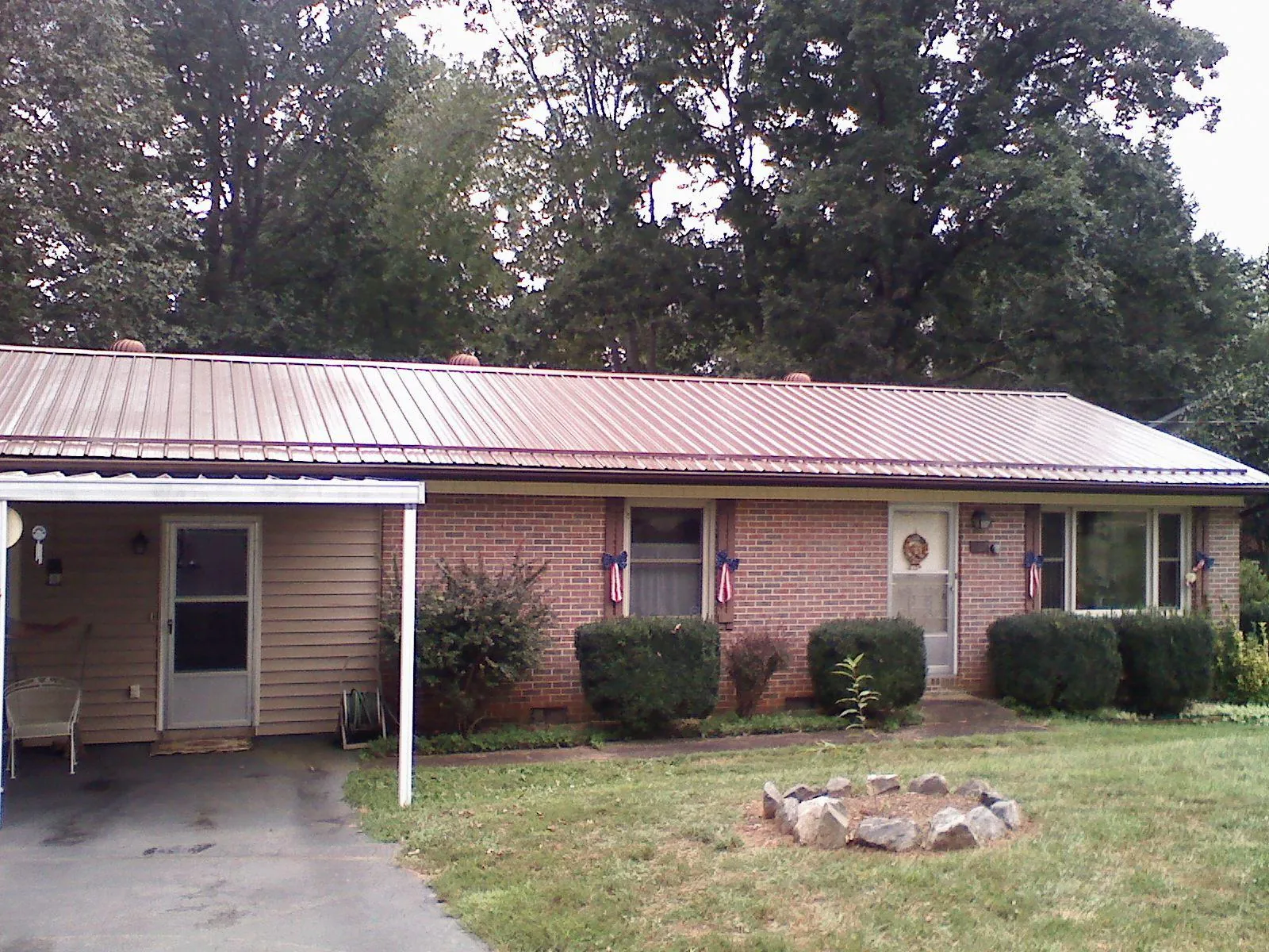 Bronze metal roof and carport on a brick ranch home — Roof Repair work by our crew in Schodack Landing